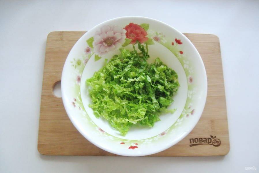 Пекинскую капусту нарежьте соломкой и выложите в салатник.