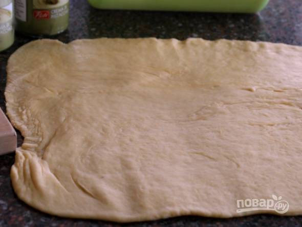 2. Через пару часов выложите тесто на рабочий стол и раскатайте тонким прямоугольником. 
