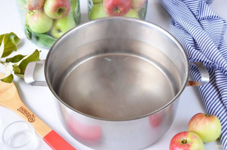 Чтобы не делать лишний маринад, я заливаю яблоки сначала холодной водой по самое горлышко, тем самым отмеряю количество. Потом слейте его в кастрюлю, добавьте соль и сахар. Доведите до кипения. Остудите до комнатной температуры. В одну двухлитровую банку входит примерно 1-1,1 литра.