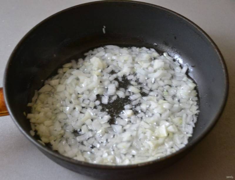 Влейте на сковороду растительное масло и обжарьте мелко нарезанный лук до прозрачности.