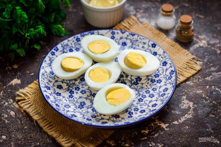 Яйца отварите 10 минут, остудите и почистите. Разрежьте каждое яйцо пополам.