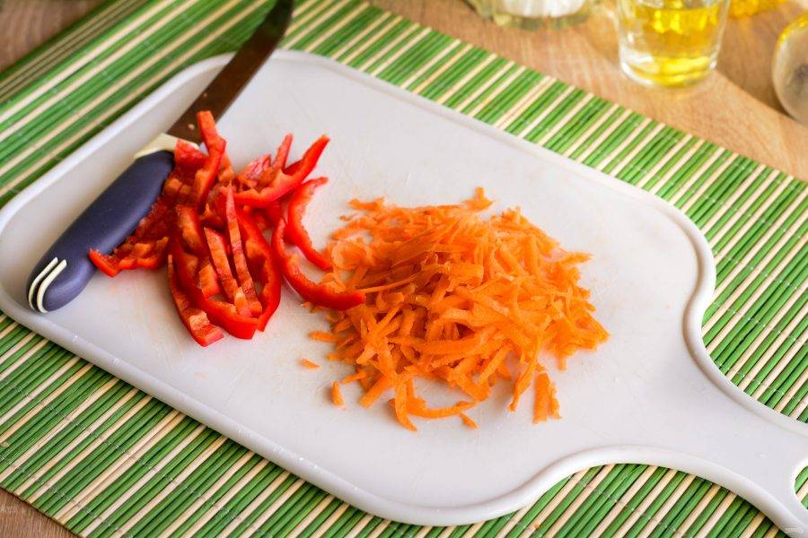 Морковку натрите на терке, а сладкий перец нарежьте полосками.