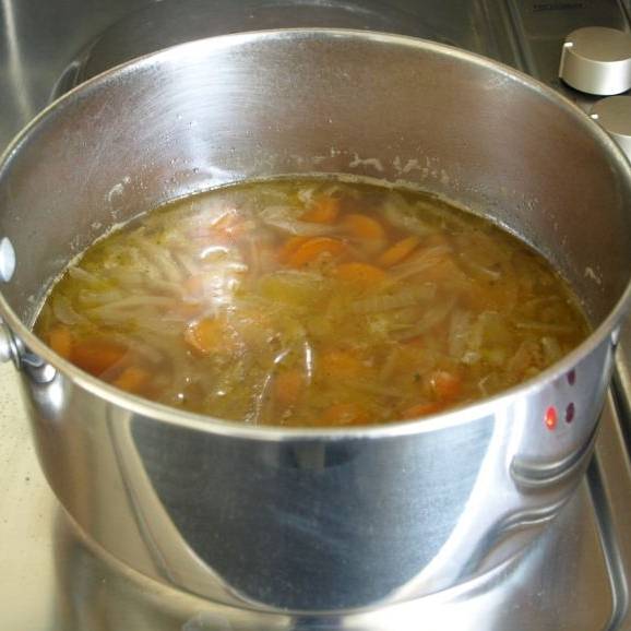 Переложите содержимого сковороды в большую кастрюлю. Добавить соль и перец. Залить овощной бульон и довести до кипения. Варить на медленном огне в течении  20 минут. Перемешайте суп несколько раз во время его приготовления.