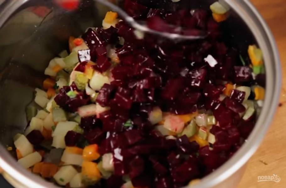 3. Нарежьте мелкими кубиками огурцы и измельчите зелень, добавьте это все в кастрюлю с картофелем и морковью. Затем добавьте свеклу и зеленый горошек, посолите, перемешайте.