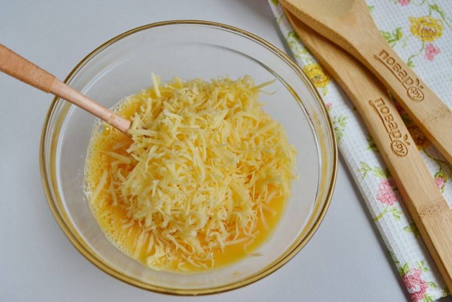 Теперь добавьте тертый сыр в яйца, перемешайте. Сыра можно и больше, если любите.