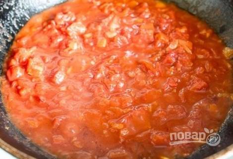 Консервированные помидоры в собственном соку разомните вилкой и соедините с куриным бульоном. Вылейте смесь к луку с чесноком, добавьте сахар и соль. Тушите соус десять минут. 