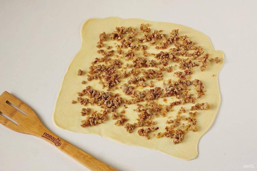 Стол и скалку смажьте растительным маслом и раскатайте тесто в форме прямоугольника, толщиной около 3 мм. Распределите равномерно начинку.