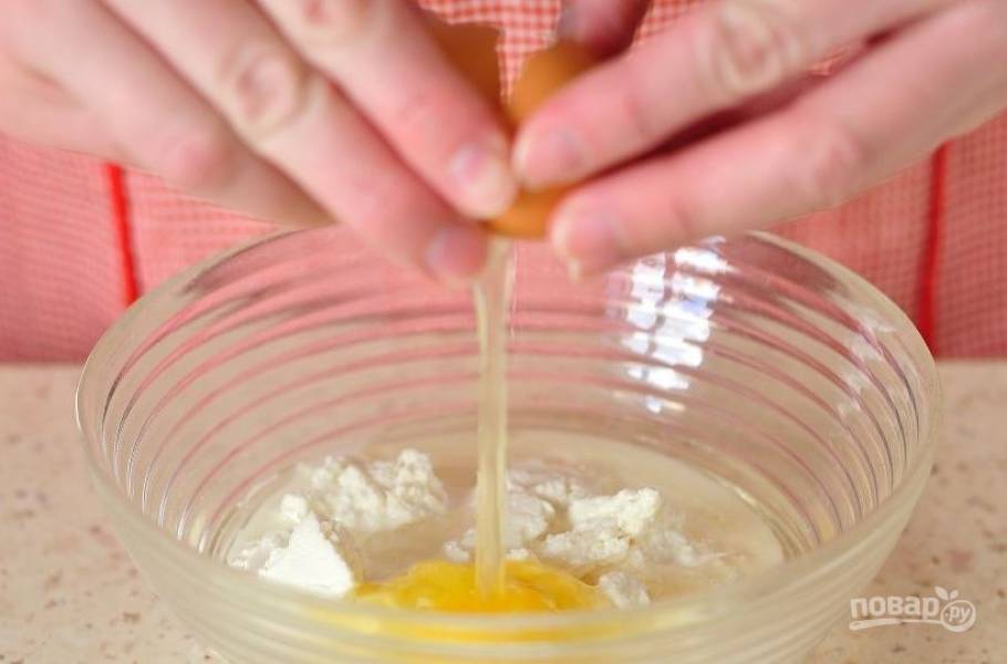 В миске с высокими бортиками смешайте творог, семьдесят пять миллилитров молока, рафинированное растительное масло, всыпьте сахар и ванилин, вбейте сырое куриное яйцо. Смешайте все ингредиенты до однородного состояния. 