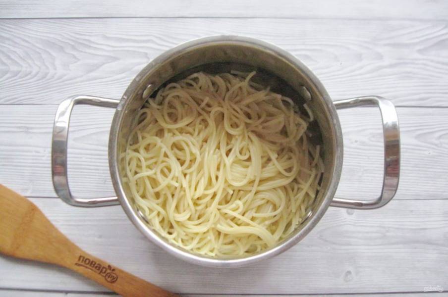 В кипящую подсоленную воду выложите спагетти и варите до полуготовности. Слейте воду.