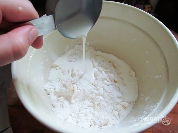 2. Добавьте холодное сливочное масло и ножом смешайте его с сухими ингредиентами. Влейте в мисочку сливки или молоко. 