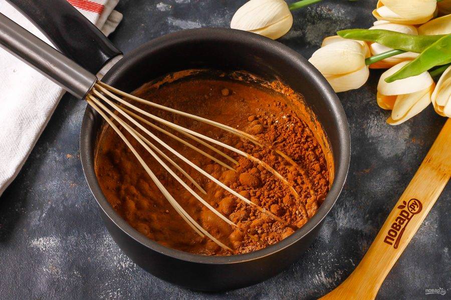 Поместите емкость на плиту и прогрейте, помешивая венчиком. Какао-порошок растворяется только в теплой жидкости, поэтому масса начнет приобретать шоколадный цвет.