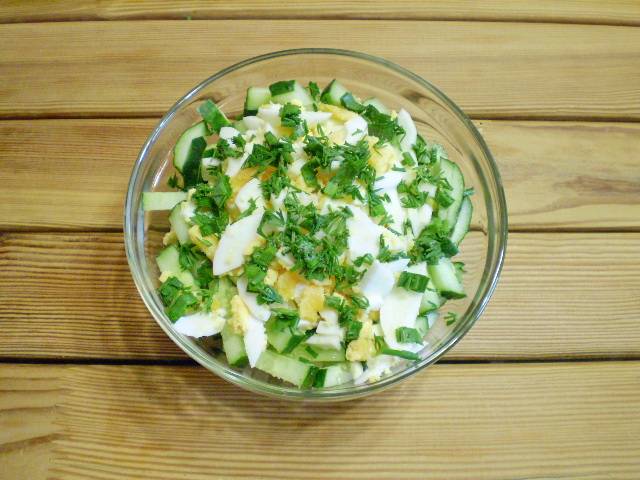 4. В салатнике соединяем огурцы, яйца, рубленую свежую зелень, соль.
