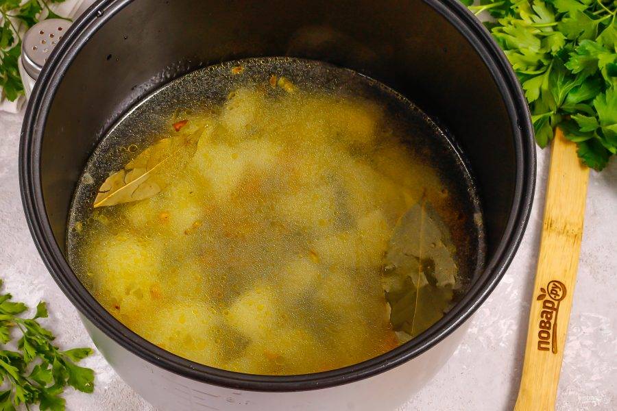 Влейте горячую воду и активируйте режим "Варка" или "Суп" на 50 минут. Всыпьте лавровые листья и соль.
