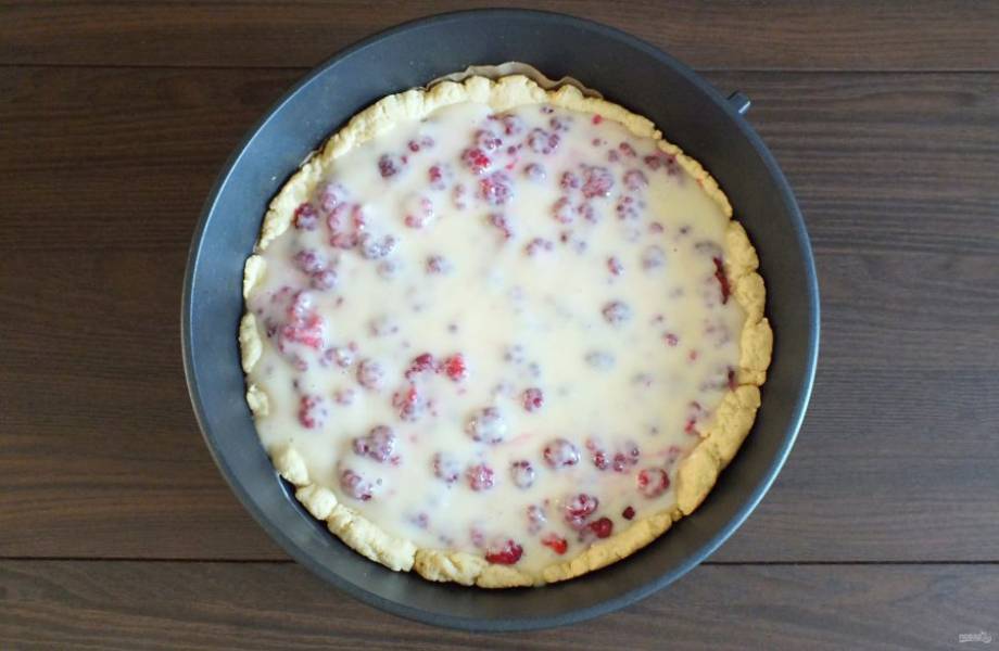 Вылейте сверху заливку. С помощью ложки распределите её по ягодам. Поставьте выпекаться пирог в разогретую до 180 градусов духовку на 35-40 минут. Учитывайте особенности своей духовки.