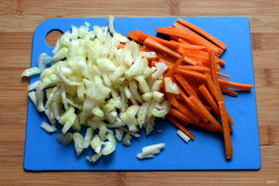 Добавьте шинкованную крупной соломкой морковь и тонко нарезанный черешковый сельдерей, обжарьте пару минут все вместе.