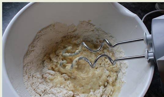 2. Приготовьте тесто: в иске размешайте растительное мало, яйца и воду. Добавьте сахар и муку. Замесите тесто.
