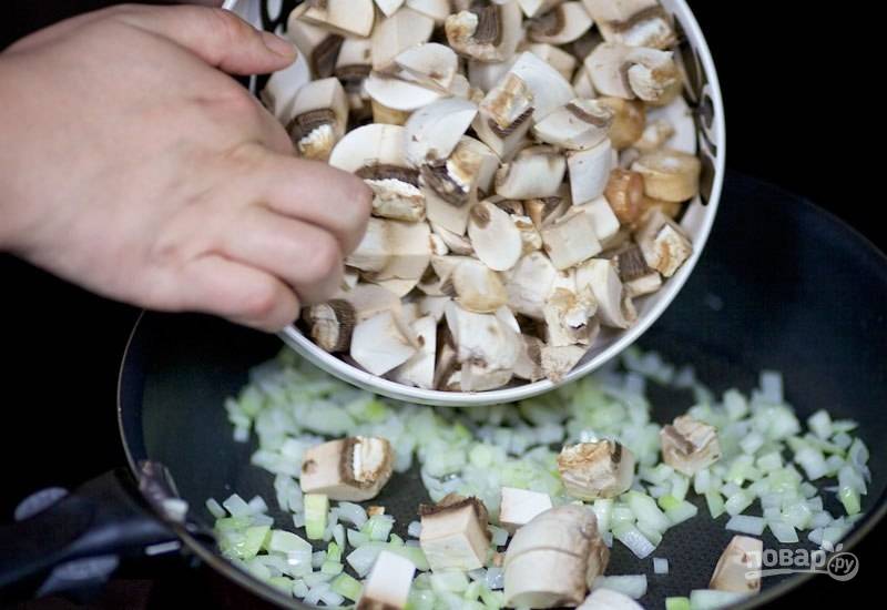 В сковороду добавьте промытые и нарезанные кубиками шампиньоны. Жарьте ингредиенты вместе, пока не испарится жидкость. Всё посолите и поперчите.