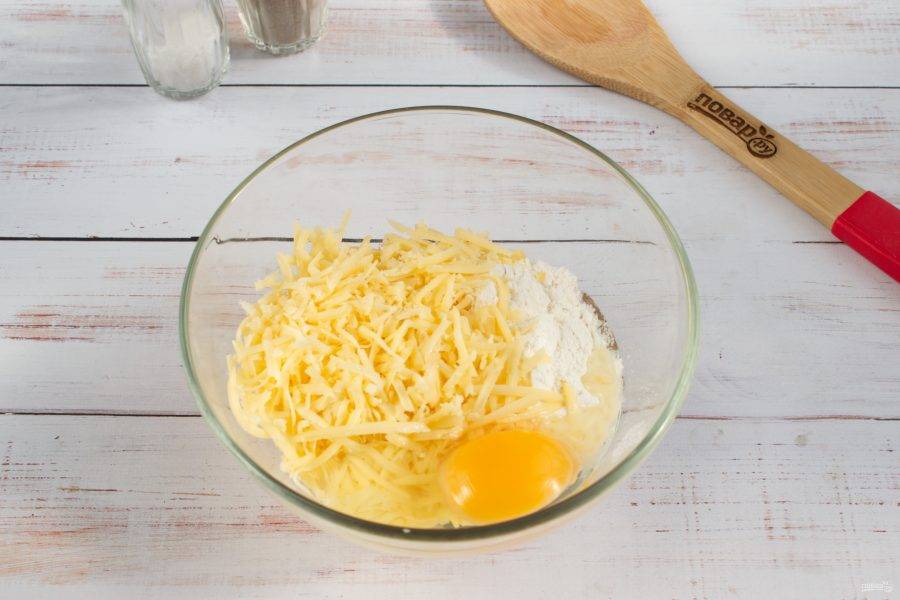 Тем временем замесите тесто для клецок. Сыр натрите на мелкой терке, соедините с яйцом, мукой, водой (1 ст. л.), растительным маслом (1 ст. л.), солью и перцем. Перемешайте до однородности. 
