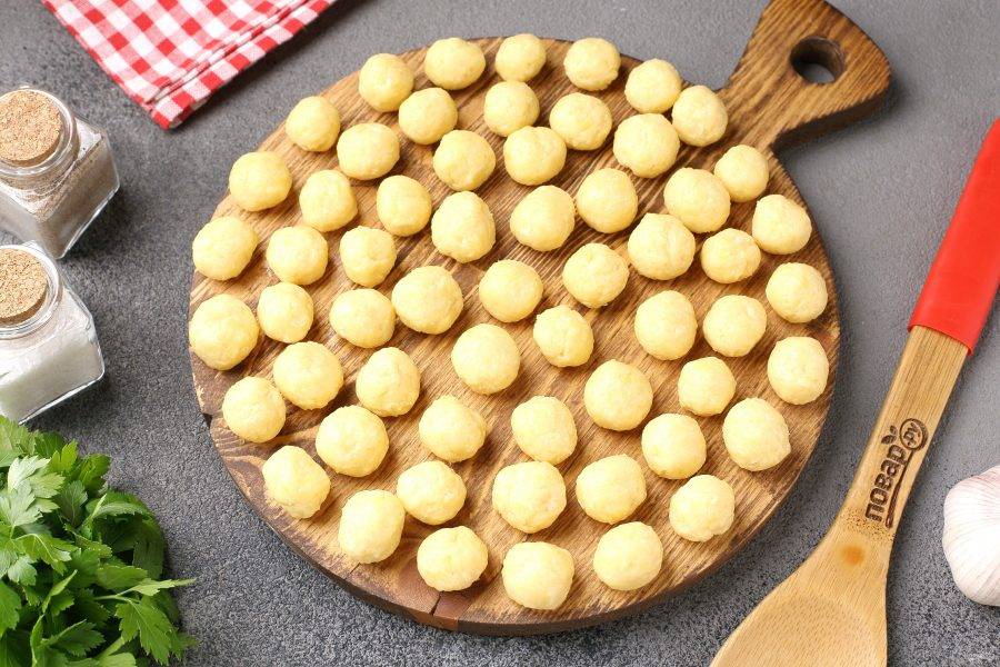 Достаньте сырное тесто из холодильника и сформируйте небольшие шарики, примерно одного размера. Когда картофель будет почти готов, опустите в бульон сырные шарики и варите 10 минут.