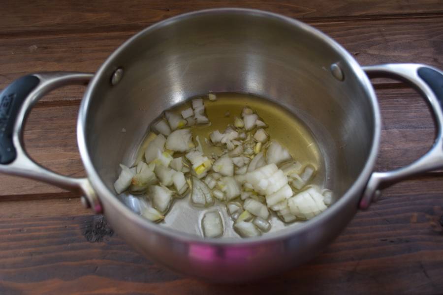 В сотейник налить растительное масло. Нарезать репчатый лук и обжарить его прям в кастрюле.