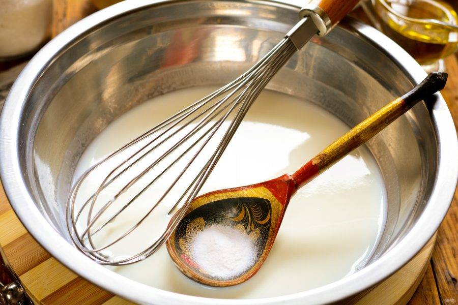 Всыпьте в кефирную массу пищевую соду, размешайте при помощи венчика. Сода вступит в реакцию и немного зашипит.