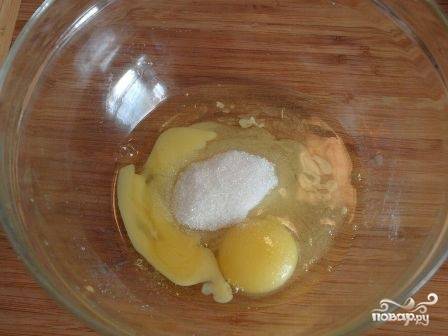 А теперь приготовим вкусное суфле-заливку для пирога. В небольшую миску вбиваем яйца, добавляем ванильный сахар и столовую ложку обычного сахара. Взбиваем.