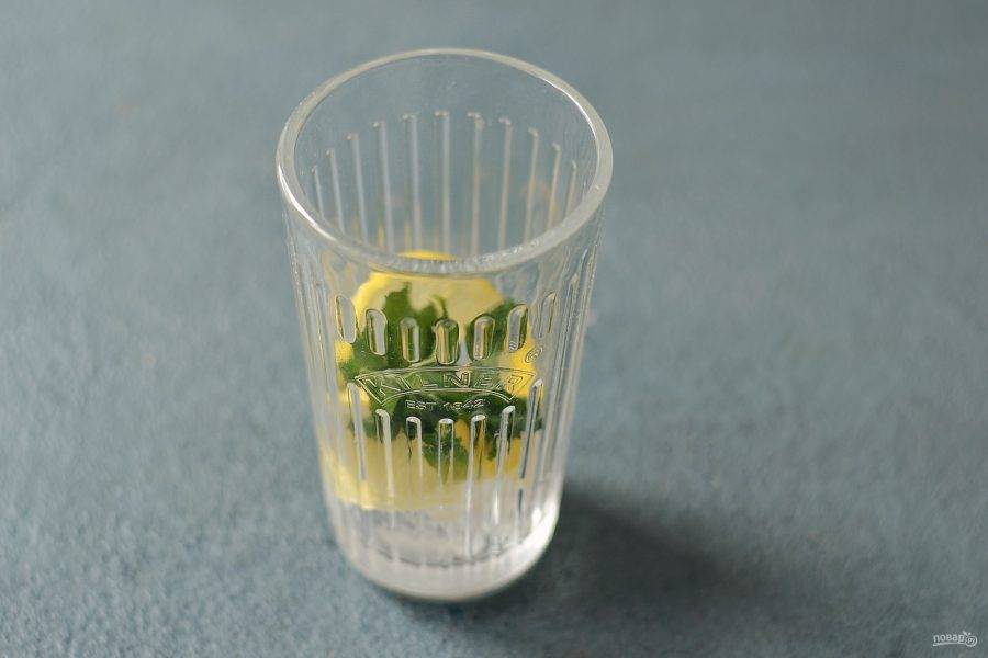 В стакан добавьте пару долек лимона и мяты.