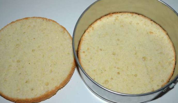 Остудите испеченный бисквит и разрежьте его пополам. Коржи можно пропитать сиропом (если хотите очень сладкий торт).