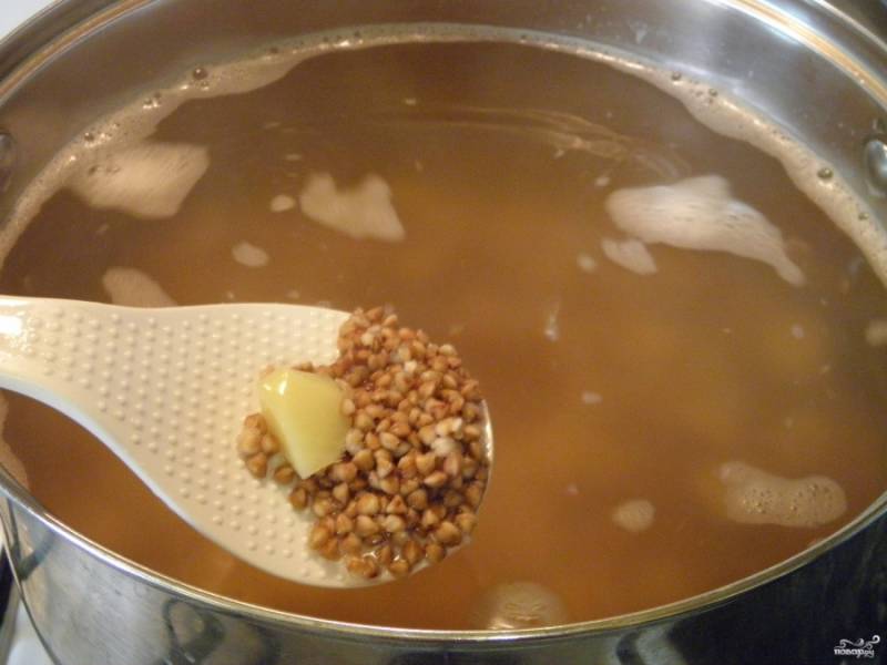 Воду для супа доведите до кипения. Посолите по вкусу. Для варки крупяных супов соль обязательно кладут вначале. Бросьте картофель и гречку. Проварите 15 минут суп.