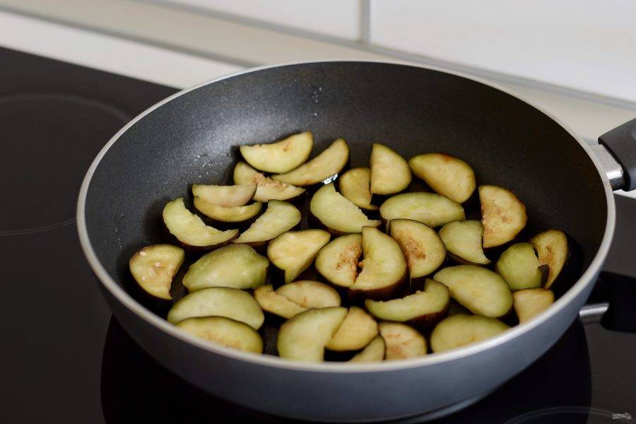 Разогрейте сковороду на среднем огне.  Обжаривайте баклажаны с растительным маслом 15 минут. Затем переложите в миску.