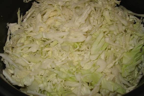 Теперь шинкуем капусту, перетираем ее с солью и выкладываем поверх кабачка и картошки. 