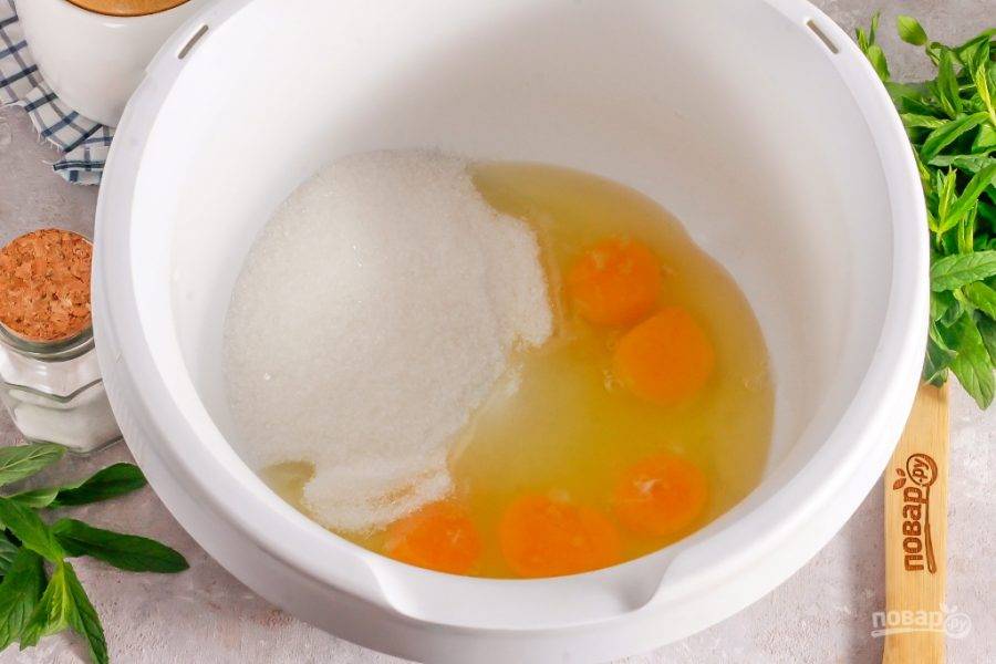 Куриные яйца вбейте в емкость кухонного комбайна и всыпьте туда же соль, сахарный песок и ванильный сахар. Взбейте примерно 4-5 минут на самой высокой скорости техники.