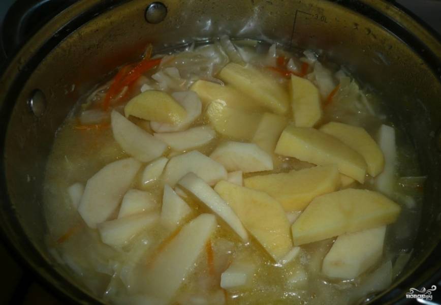 Картофель очистите и вымойте. Нарежьте дольками или брусочками. Бросьте нарезанные клубни к кислой капусте и перемешайте. Варите под закрытой крышкой на медленном огне на протяжении пятнадцати минут.