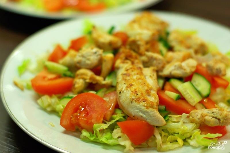 На тарелочку выкладываем овощи, сверху кладем кусочки курицы.