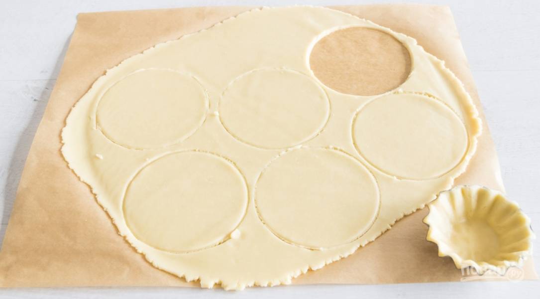 Затем раскатайте тесто и нарежьте его кругами и поместите его в формочки, делая несколько проколов вилкой в тесте. Духовку разогрейте до 175С. Поставьте выпекаться корзиночки на 10 минут.