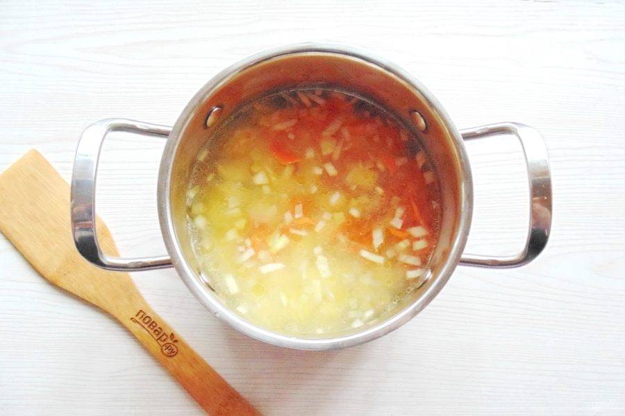 После переложите обжаренные лук и морковь в кастрюлю с картофелем. Посолите, поперчите суп и продолжайте варить до готовности овощей.