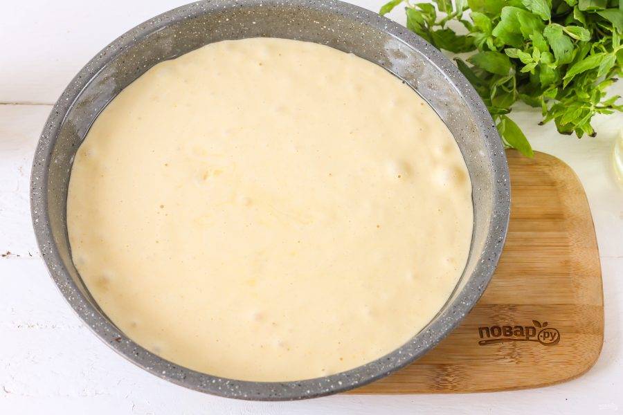 Смажьте форму растительным или сливочным маслом и вылейте в нее бисквитное тесто, аккуратно разровняйте поверхность заготовки и поместите форму в духовку на 25 минут.