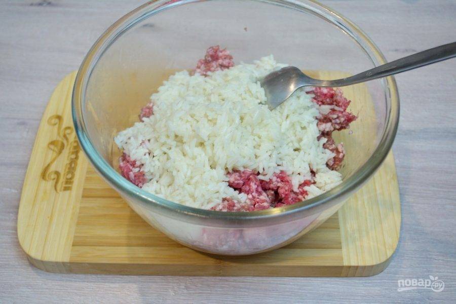 В миску к фаршу добавьте слегка проваренный рис.  Рис перед добавлением к мясу нужно остудить.