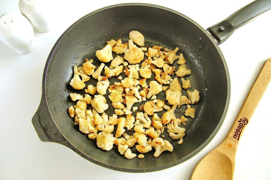 Поставьте сковороду на плиту, налейте масло, нагрейте и положите соцветия капусты. Обжарьте периодически помешивая на среднем огне до готовности. В конце добавьте измельченный чеснок, соль по вкусу и молотый перец.