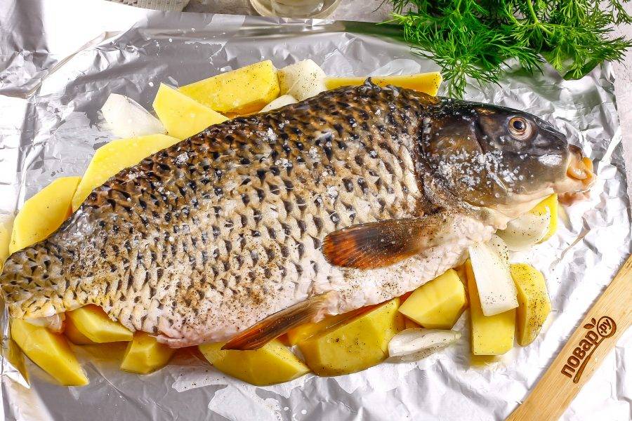 Посолите и поперчите рыбу и овощные нарезки. Смажьте фольгу или форму растительным маслом, выложите на нее нарезанные овощи, а на них — рыбу. Разогрейте духовку до 210 градусов.