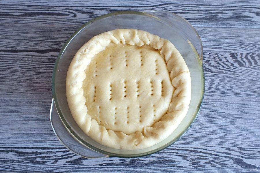 Верх пирога прикройте третьим малым пластом, края подогните "веревочкой". Вилкой сделайте проколы по поверхности пирога. Поставьте в разогретую до 100 градусов духовку на 30 минут.