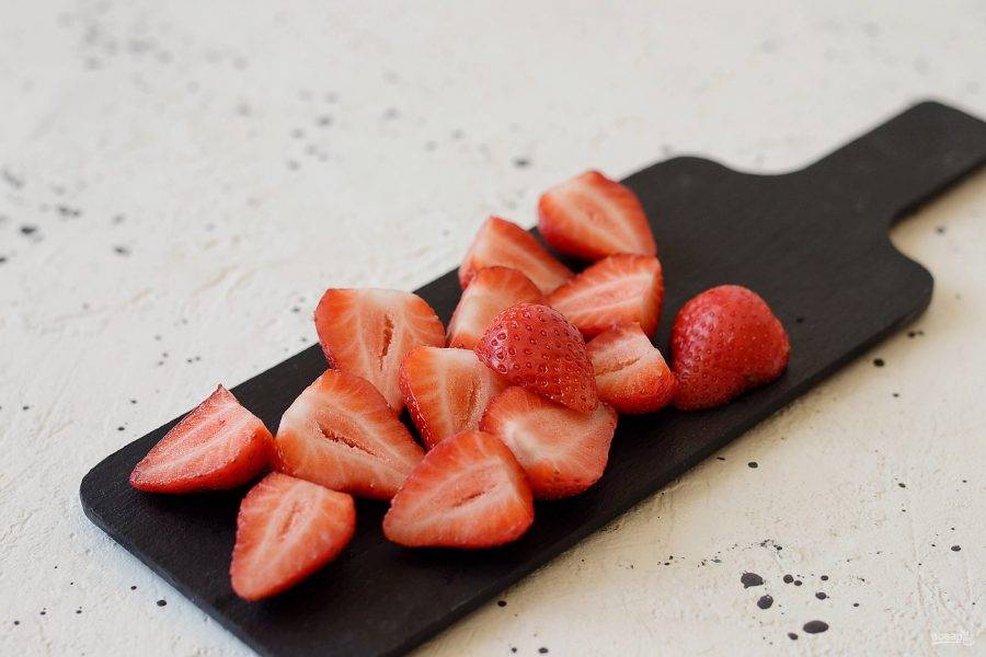 Клубнику помойте, удалите хвостик и обсушите. Разрежьте пополам. Крупные ягоды можно разрезать на 4 части. 
