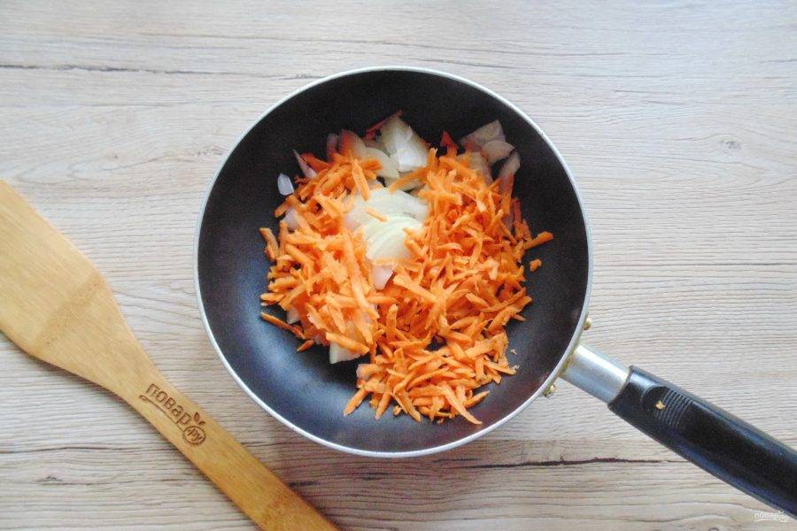Лук очистите, помойте и нарежьте полукольцами. Морковь очистите, помойте и натрите на тёрке. Выложите в сковороду с подсолнечным маслом.