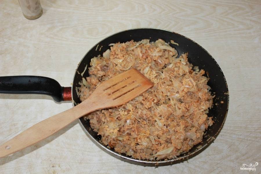 Пока поджаривается капуста и лук, измельчите при помощи ножа рыбью икру и жир. Смешайте оба компонента, выложите к овощам на сковородку. Обжаривайте, постоянно перемешивая. Икра готовится очень быстро. Она будет готова, когда приобретет характерный розовато-золотистый оттенок. Добавьте к ингредиентам соль, перец и лаврушку. Перемешайте все содержимое сковородки. 
