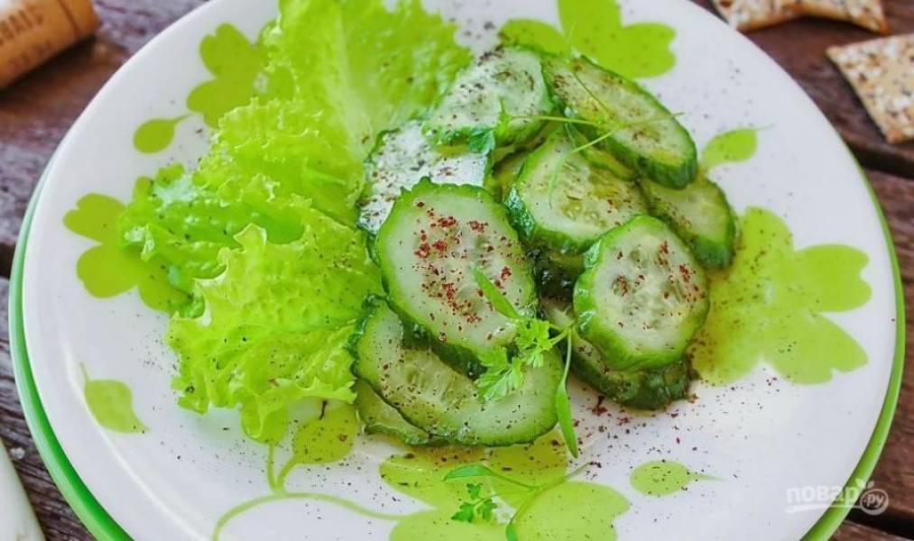 Вымойте салат и разберите его на листья. Выложите их на тарелку, а поверх положите нарезанные огурцы с заправкой. Присыпьте огурцы молотым сумахом и сушеной мятой, затем украсьте веточками зеленой петрушки. 