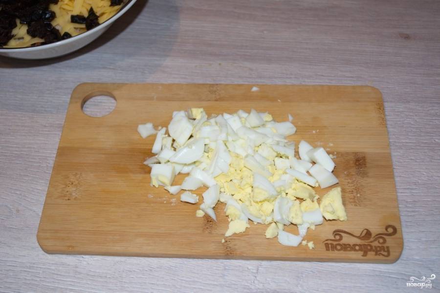 Отварные яйца остудите, очистите и нарежьте кубиками. Добавьте в салат.