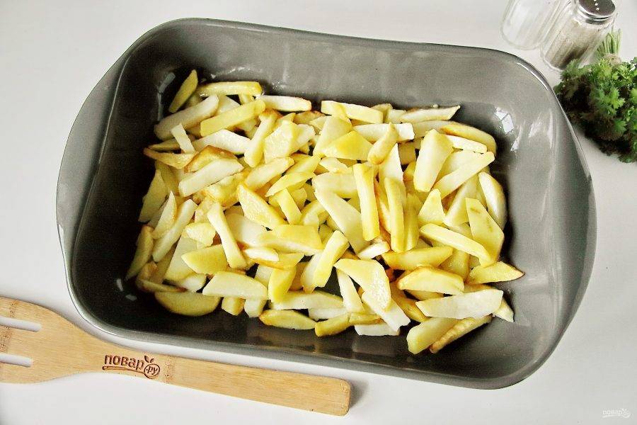 Форму для запекания смажьте маслом и положите ровным слоем обжаренный картофель.