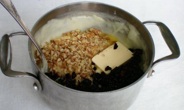 7. Теперь добавим чернослив, измельченные орехи и сливочное масло. Перемешаем.