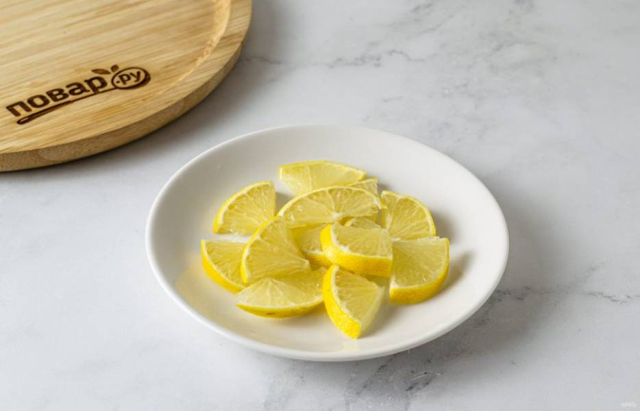 Лимон нарежьте тонкими ломтиками.