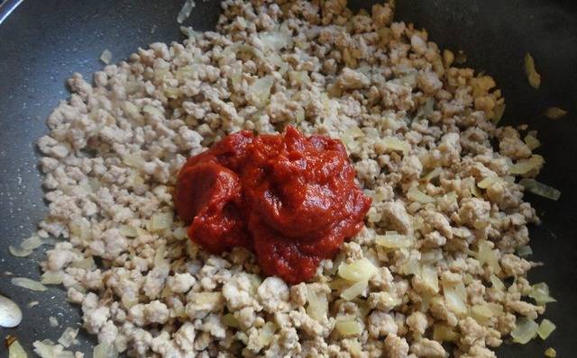 Когда сок выпарится, добавляем к фаршу томатную пасту, перемешиваем.